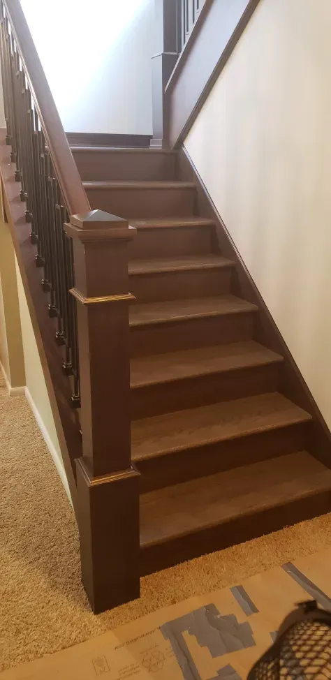 A wooden staircase with a metal railing in a house.