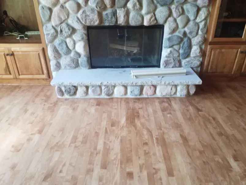 A living room with a fireplace and a wooden floor.