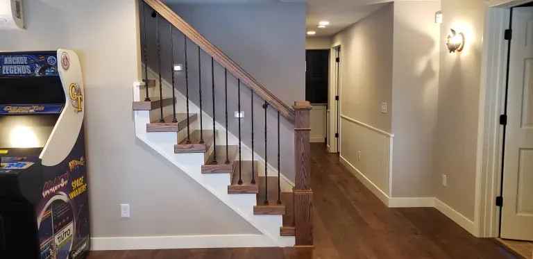 A staircase in a basement with a game machine in the background.