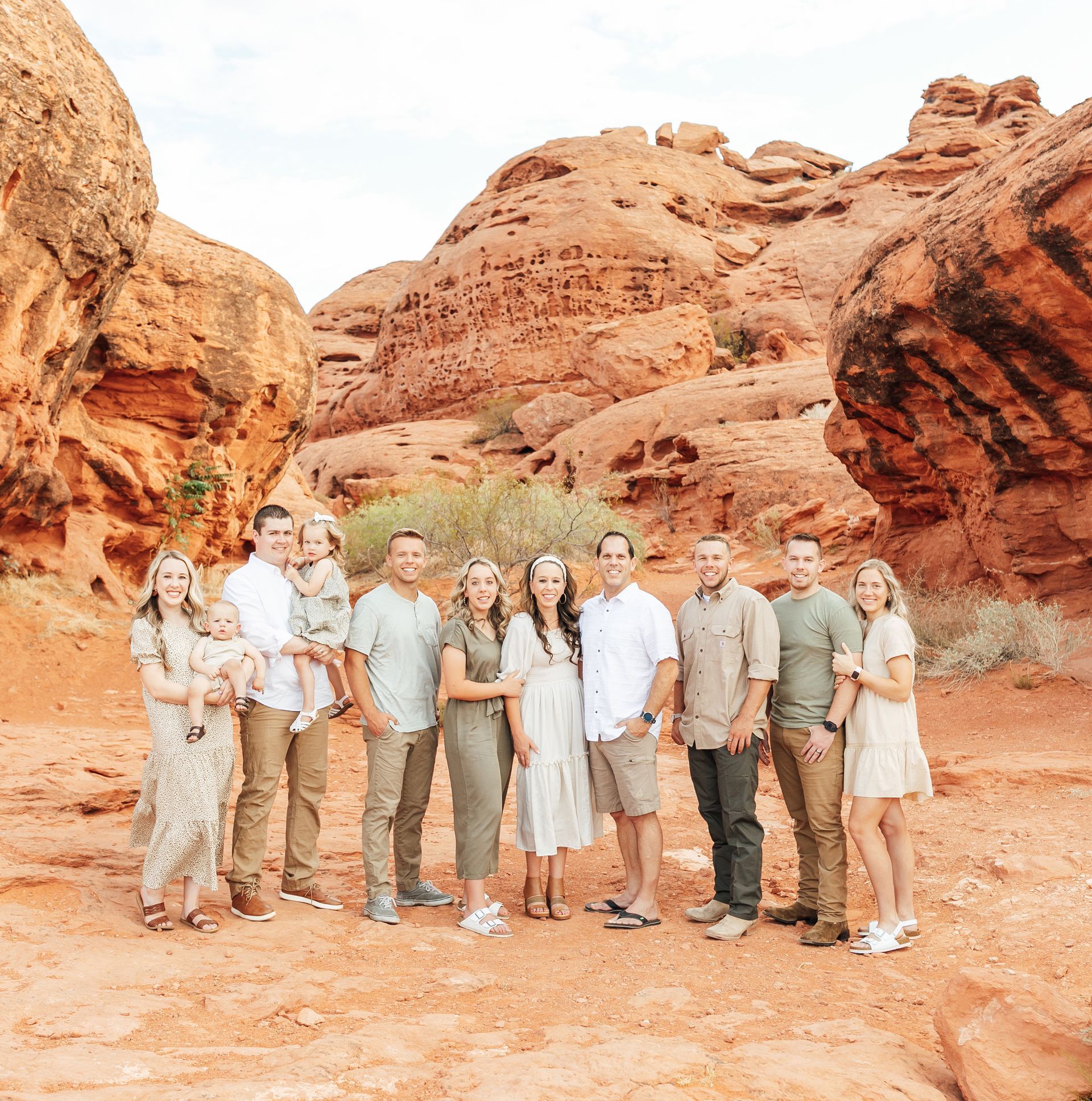 Group of people standing together in a red rock canyon landscape under bright daylight