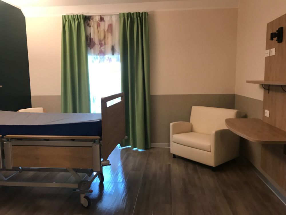 letto e poltrona in camera di una casa di riposo