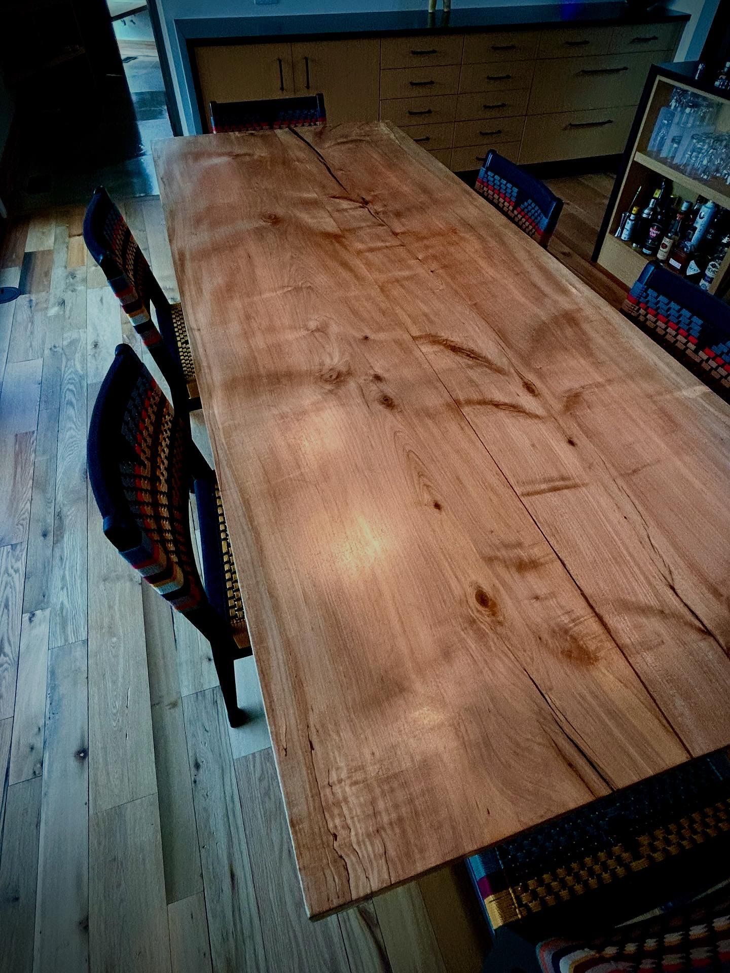 A wooden table with black metal legs is sitting in a garage.
