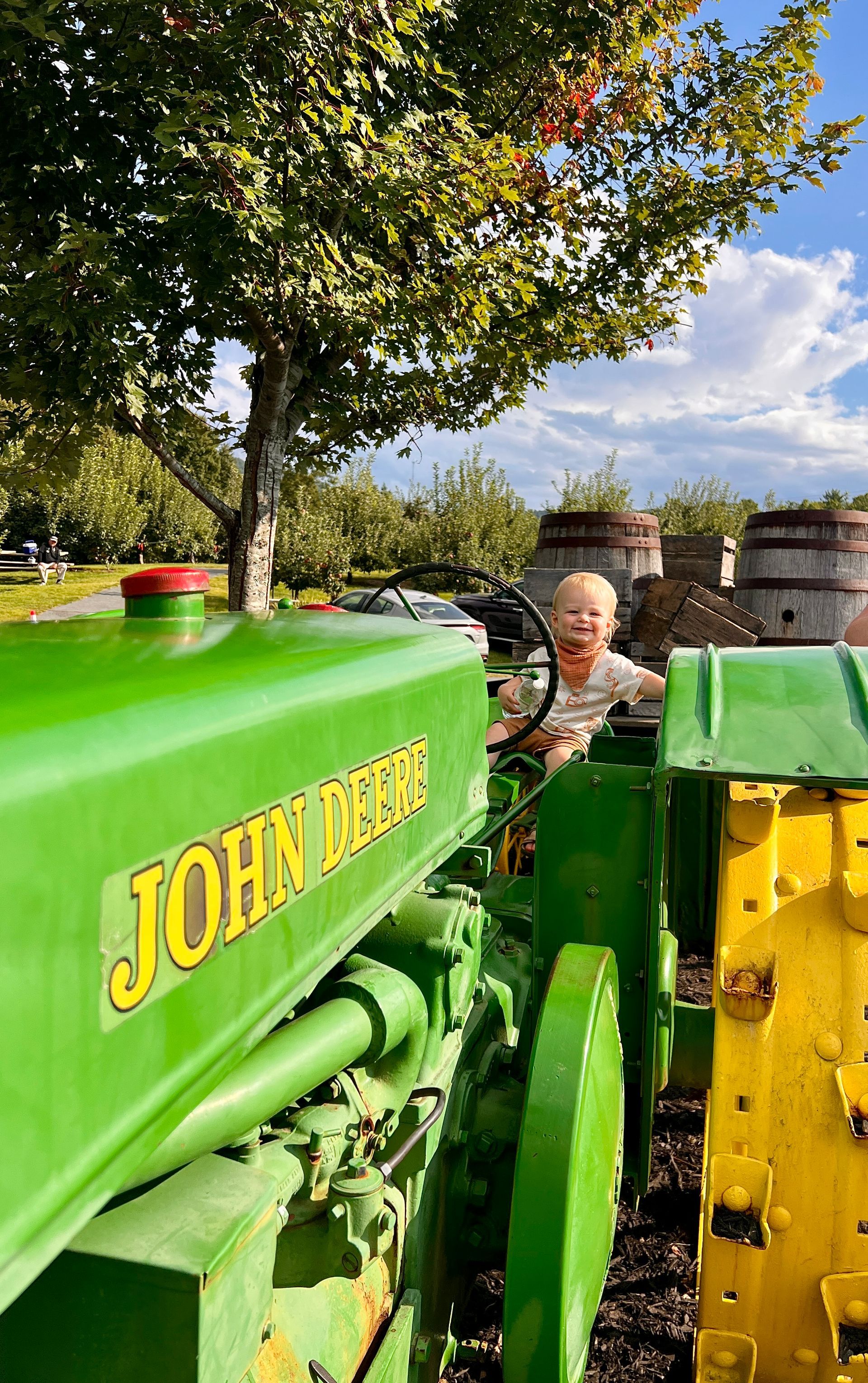 A man with a beard is wearing a blue plaid shirt and smiling.