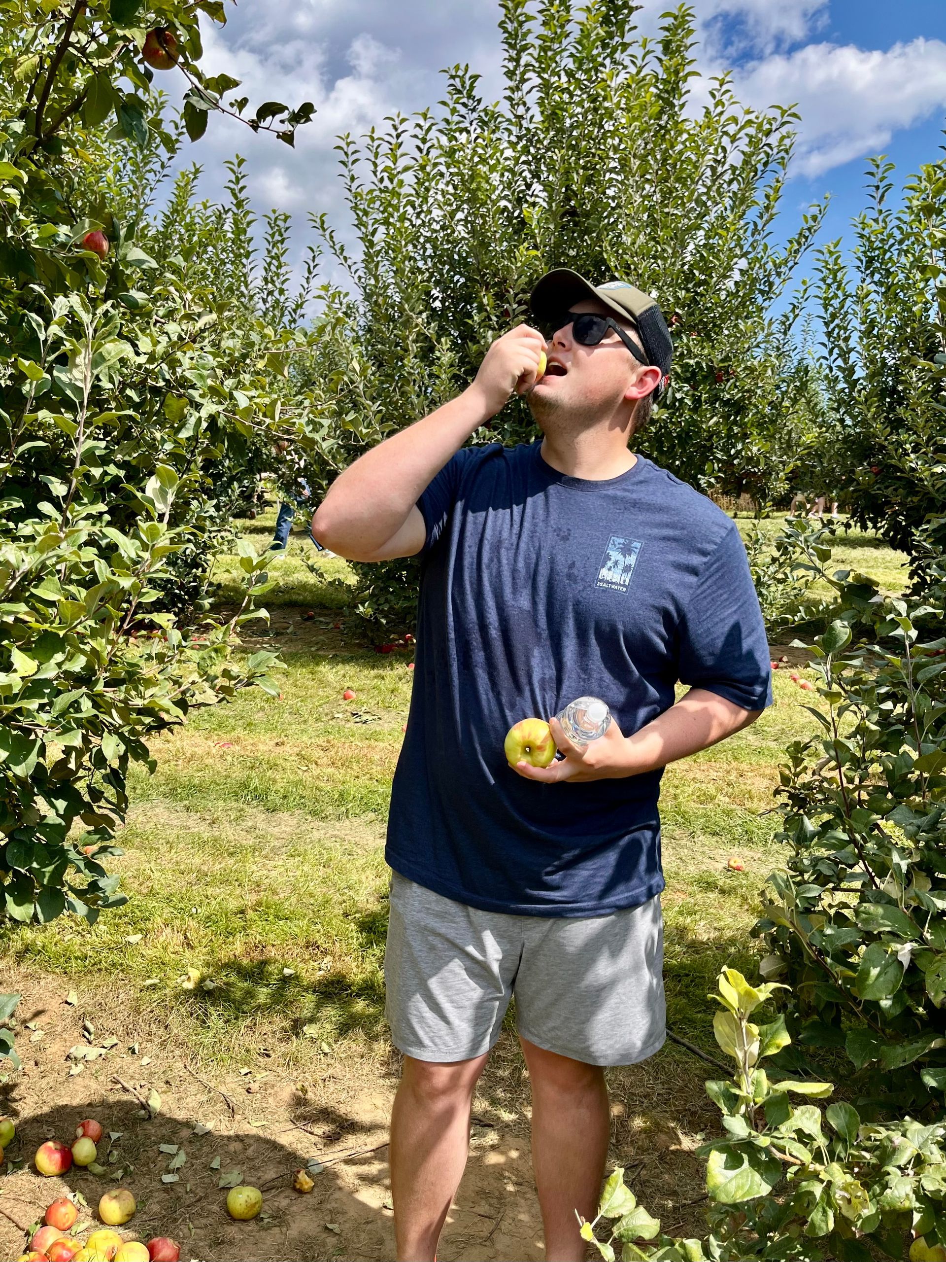 A man with a beard is wearing a blue plaid shirt and smiling.