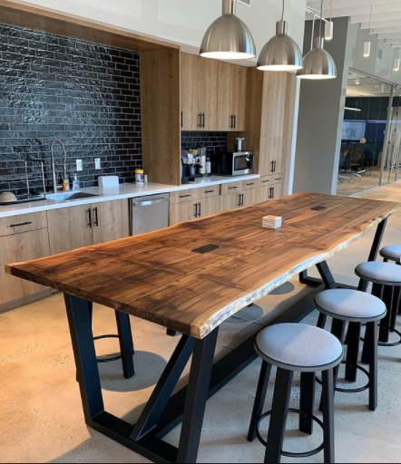 A kitchen with a long wooden table and stools