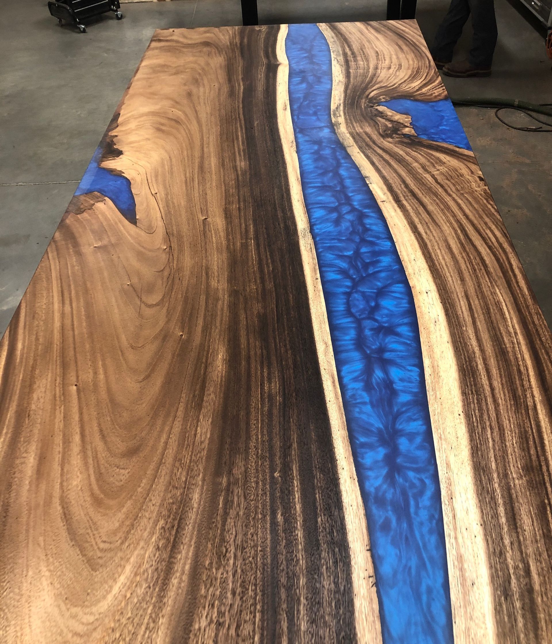 A wooden table with a blue river in the middle of it.