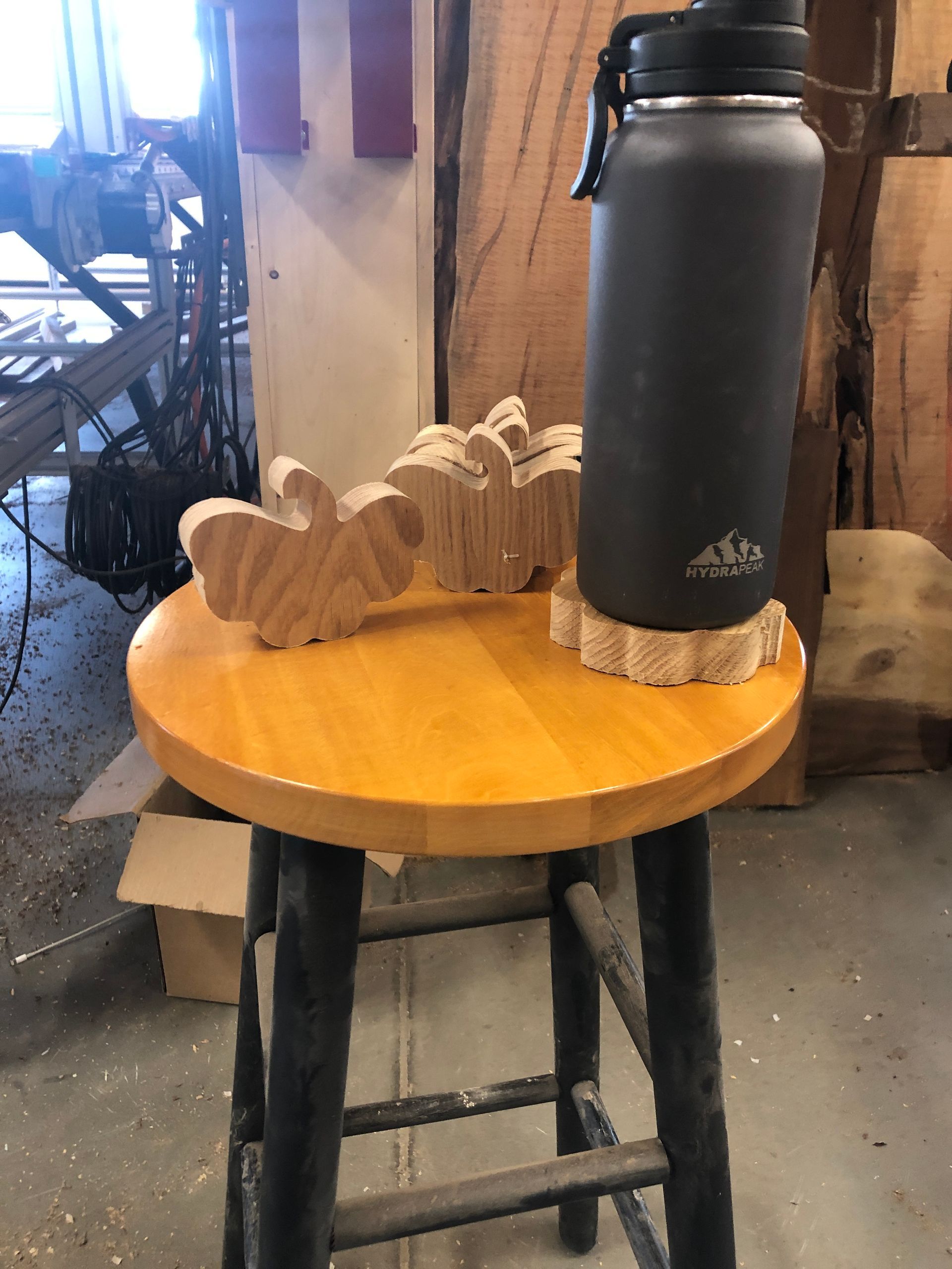 A wooden stool with a water bottle on top of it