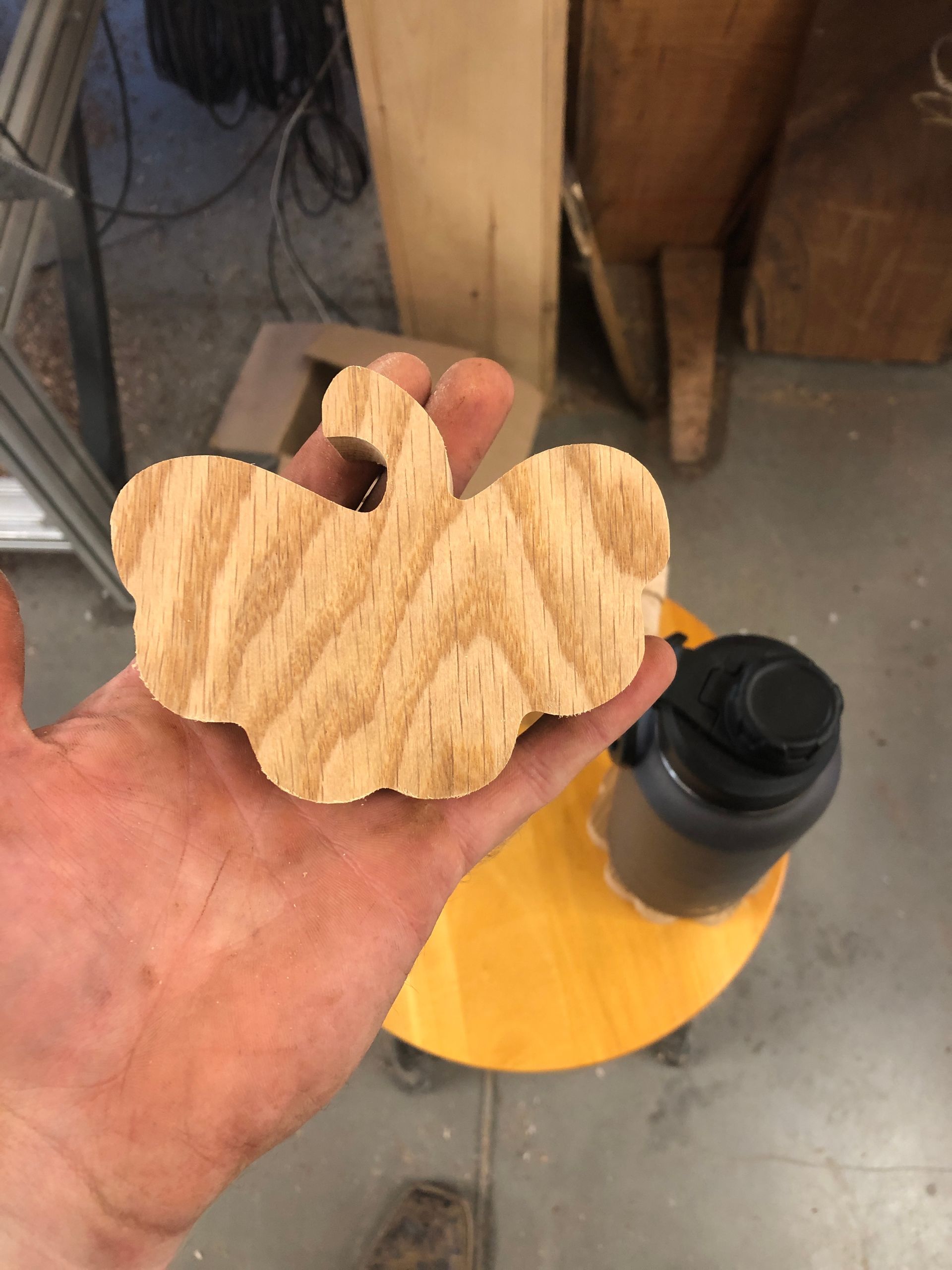 A person is holding a wooden pumpkin in their hand