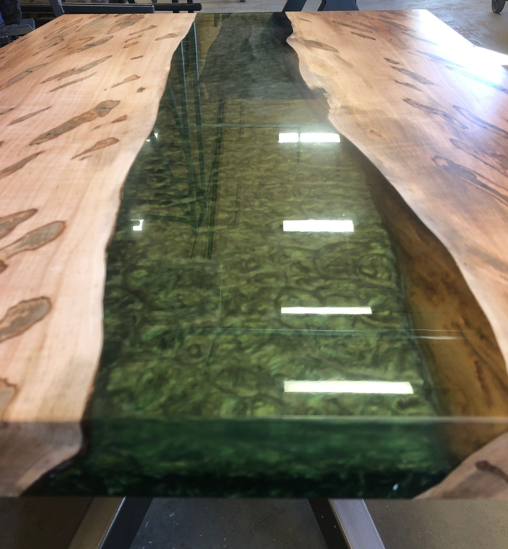 Wooden table with green epoxy river down the center.