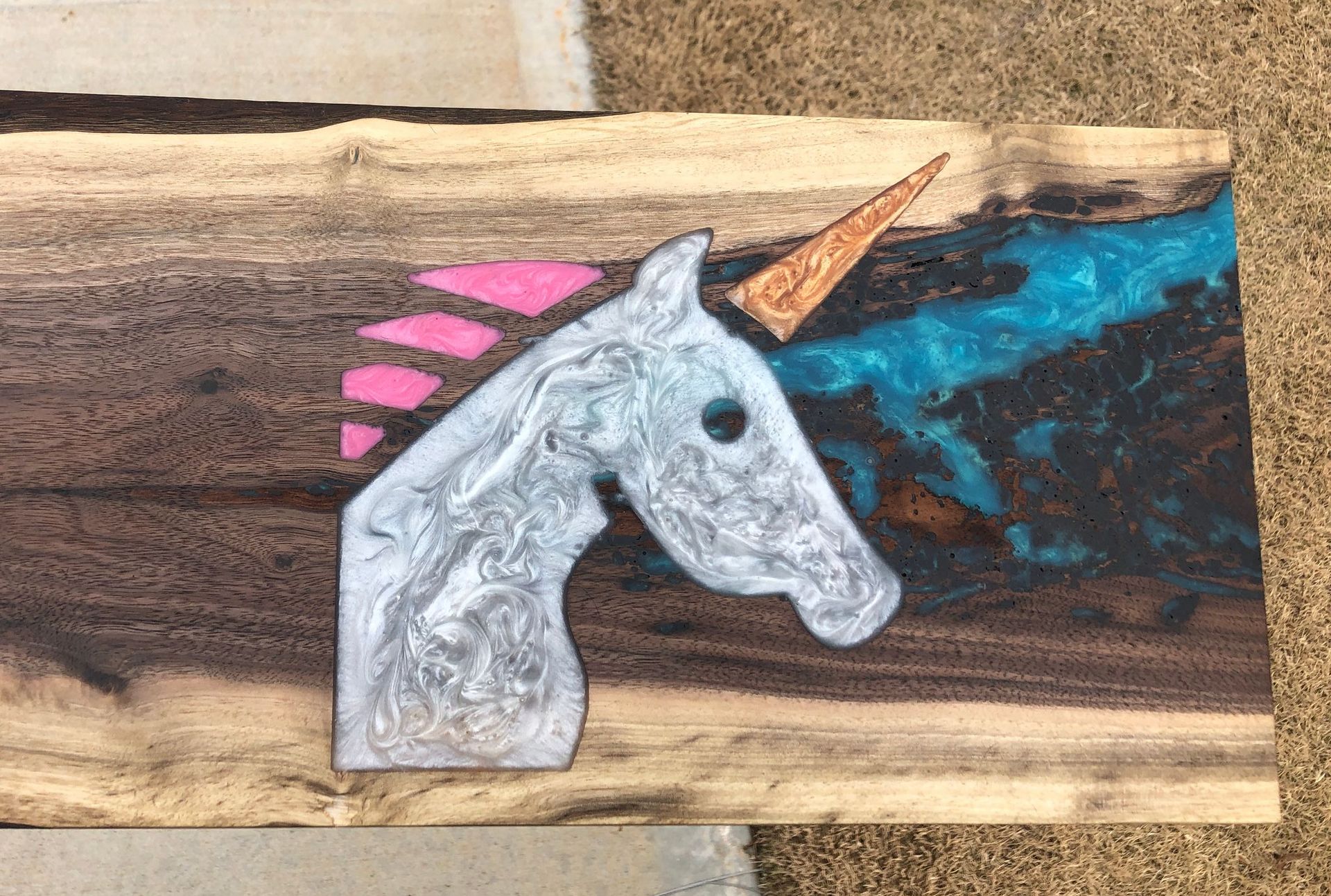 A painting of a unicorn on a piece of wood.