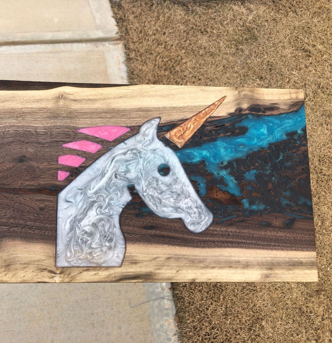 A unicorn is painted on a piece of wood.