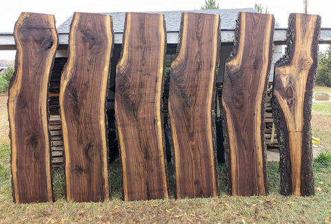 A wooden table with a black metal base is sitting in a kitchen.