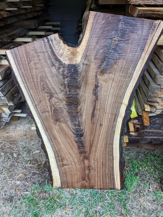 Large walnut wood slab with natural edges, featuring dark and light brown tones.