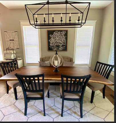 A dining room with a wooden table and chairs