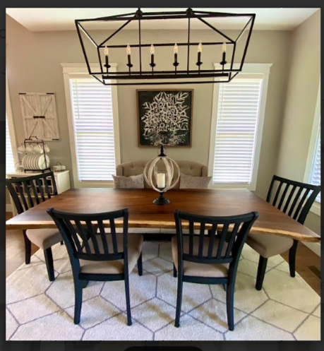 A dining room with a table and chairs and a chandelier