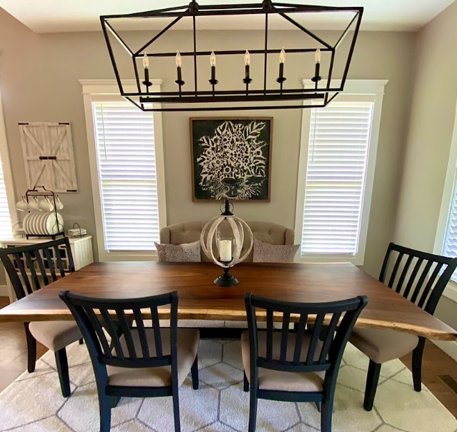 A dining room with a table and chairs and a chandelier