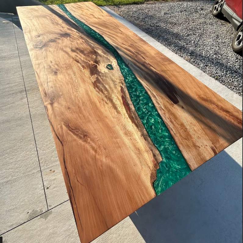 A wooden table with a blue river in the middle of it.