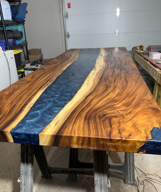 A wooden table with a blue river in the middle of it.