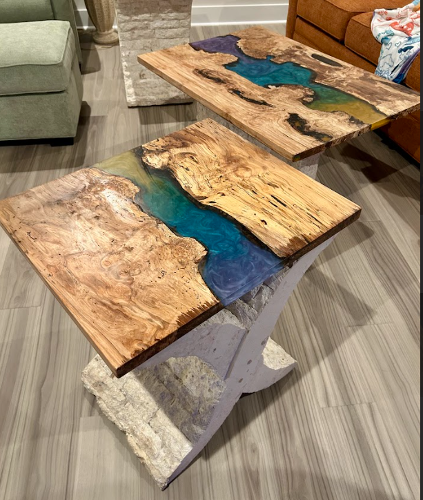 Two custom wood and epoxy resin tables with stone bases.