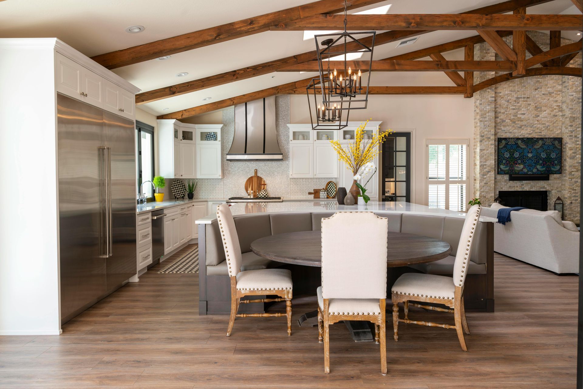 There is a table and chairs in the middle of the kitchen.