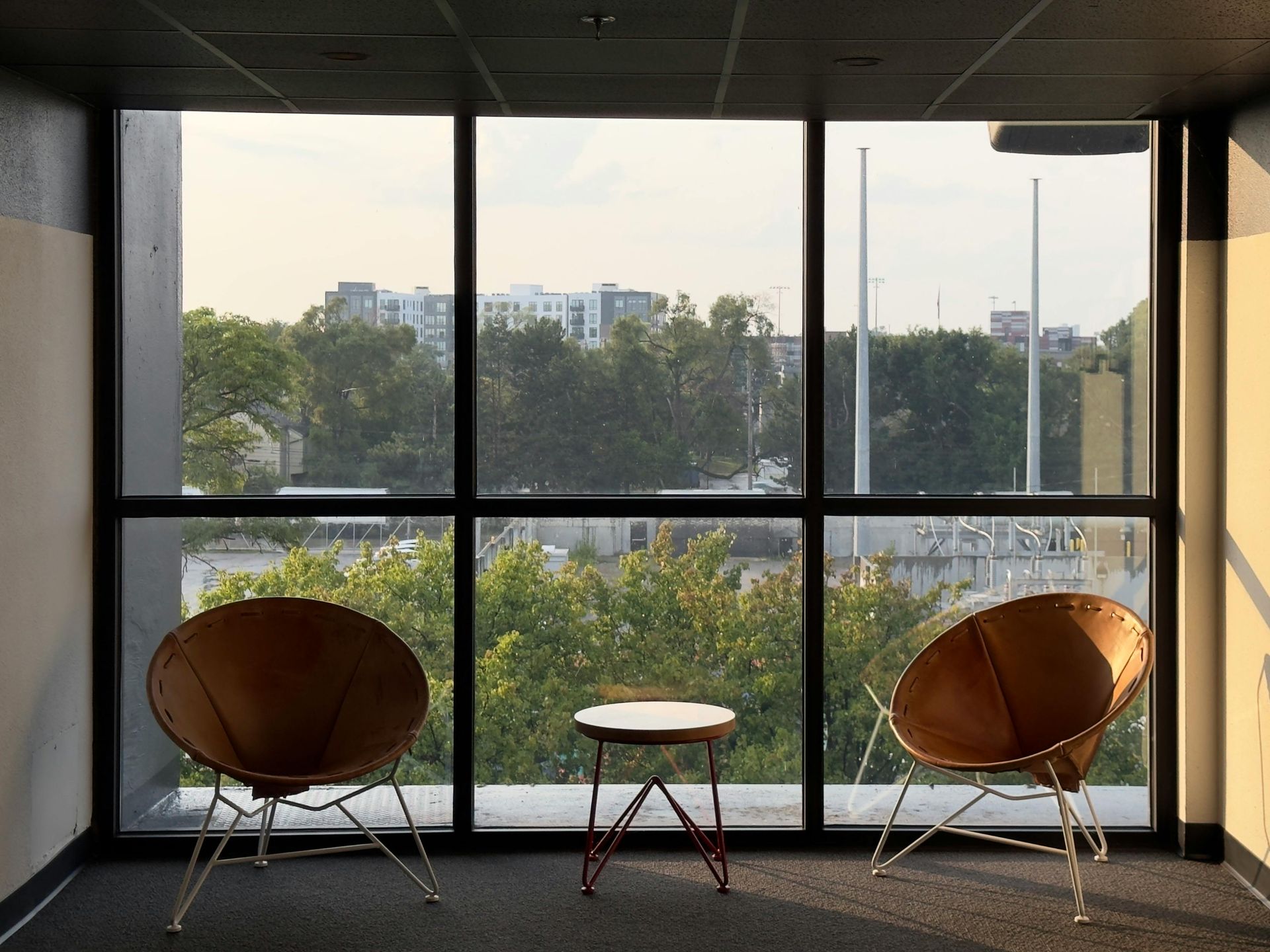 Two chairs and a table in front of a large window.