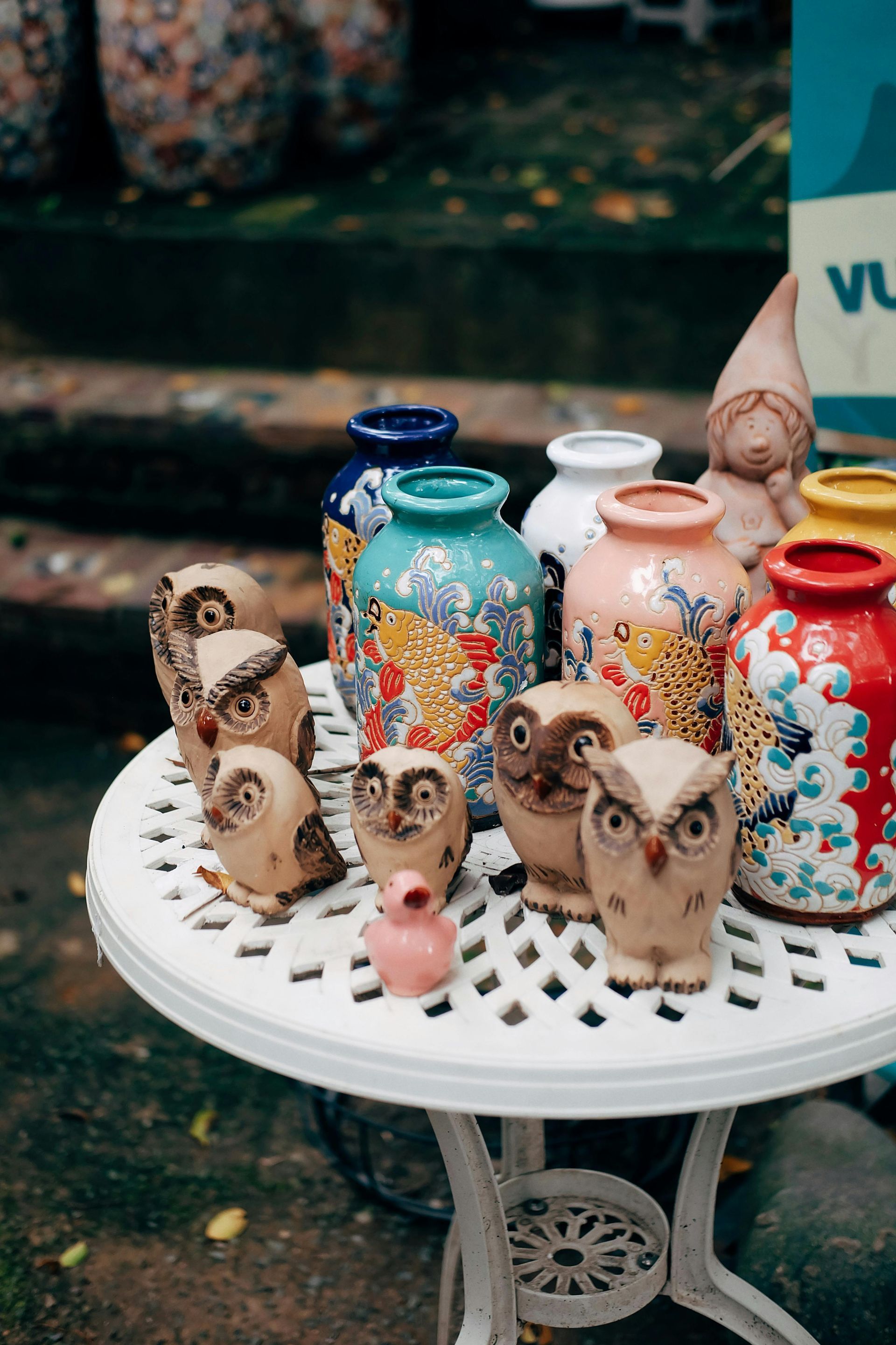 A table topped with vases and owl figurines.