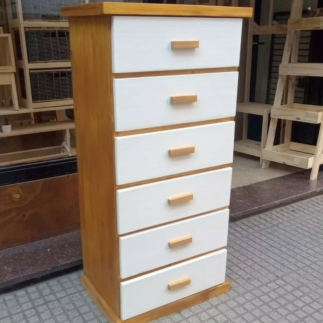 Cómoda alta de madera con seis cajones blancos y detalles en madera.