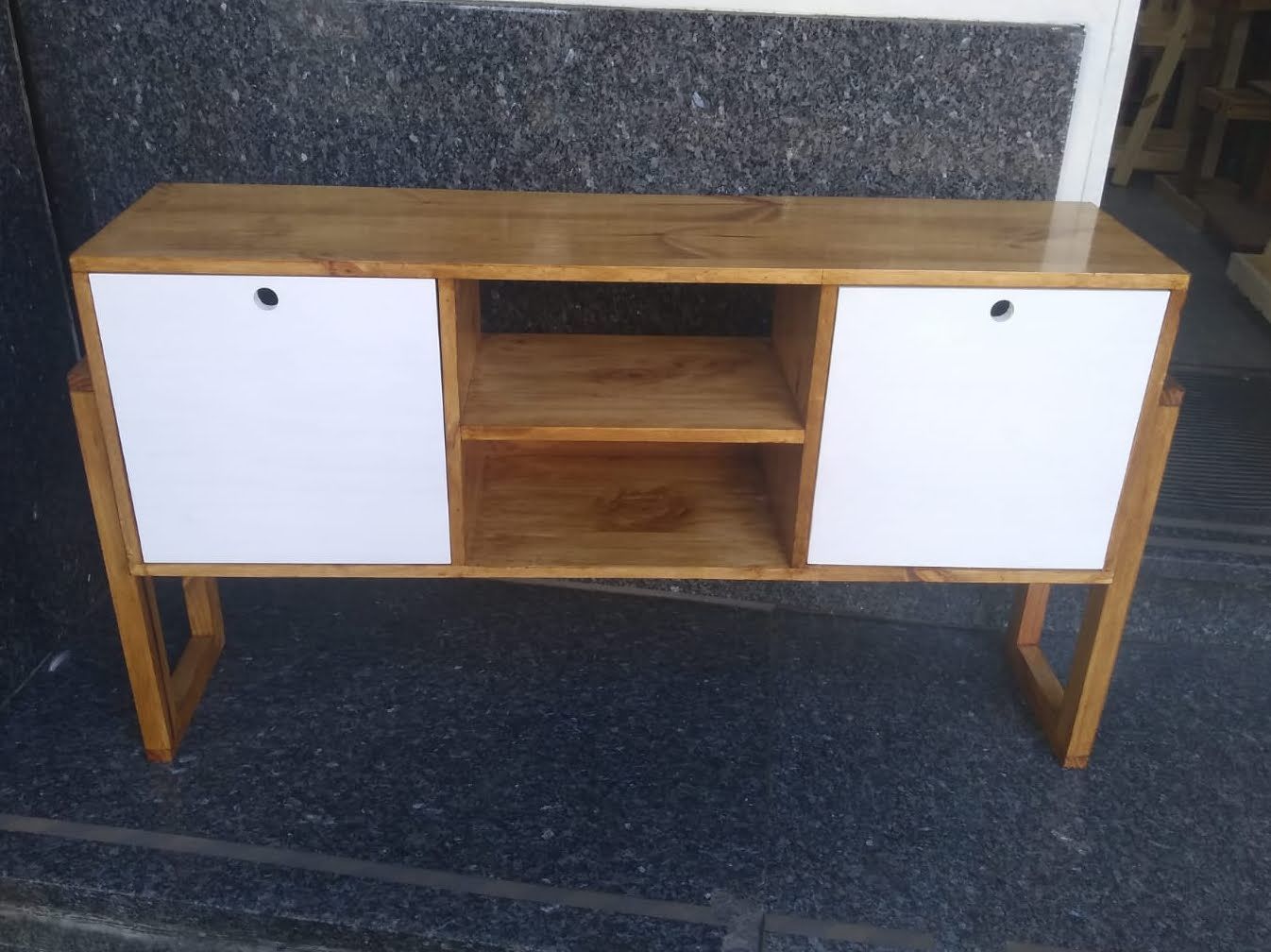 Mueble de madera con puertas blancas y estantes hexagonales.