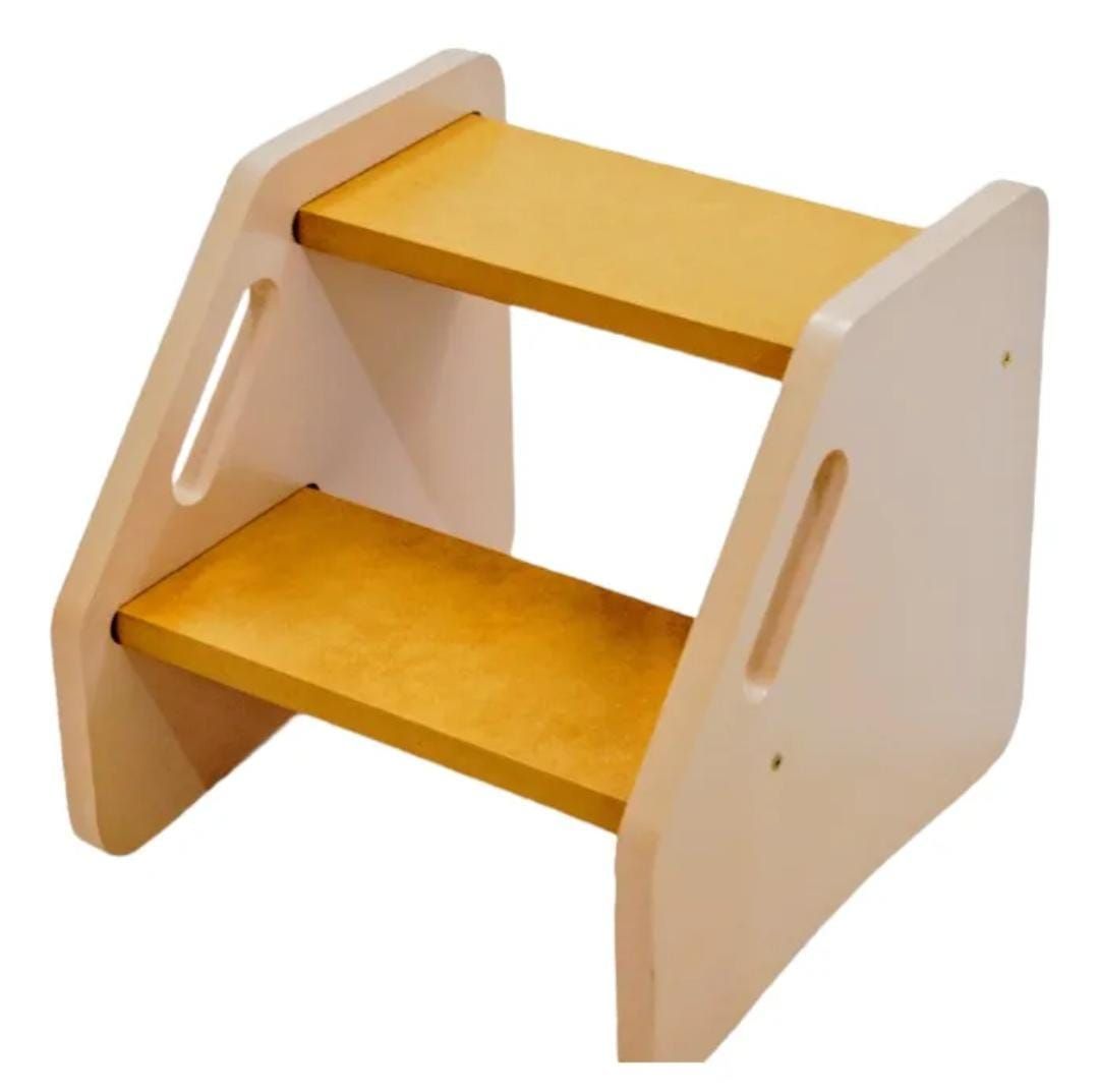 Taburete de madera de dos peldaños con asas integradas. Beige, en un ambiente neutro.