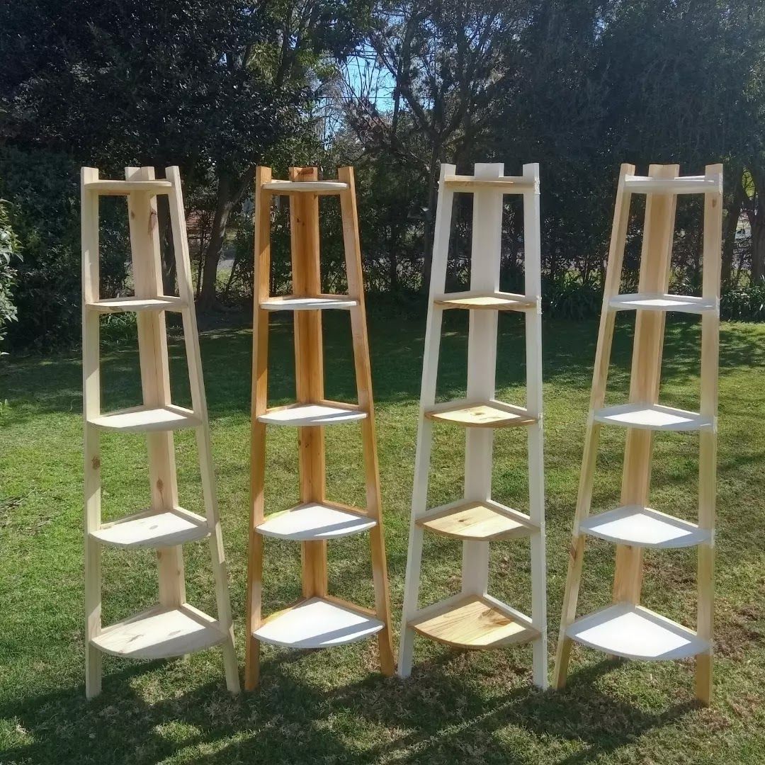 Estantes esquineros de madera con plantas y cartel 