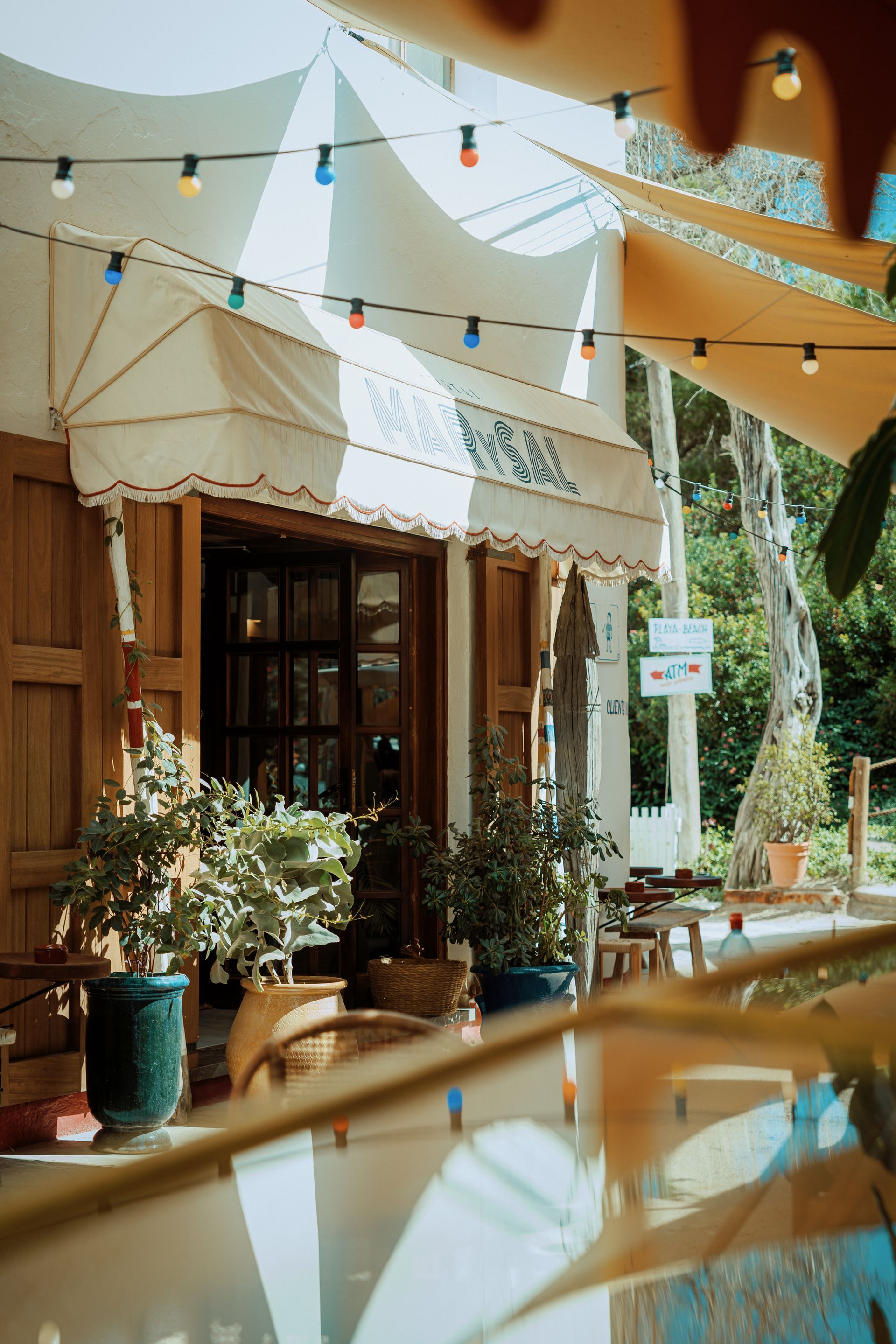 A restaurant with a lot of tables and chairs outside.