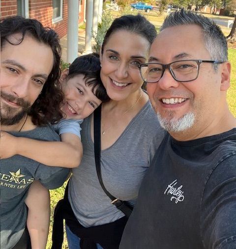 A group of people posing for a picture in front of a house