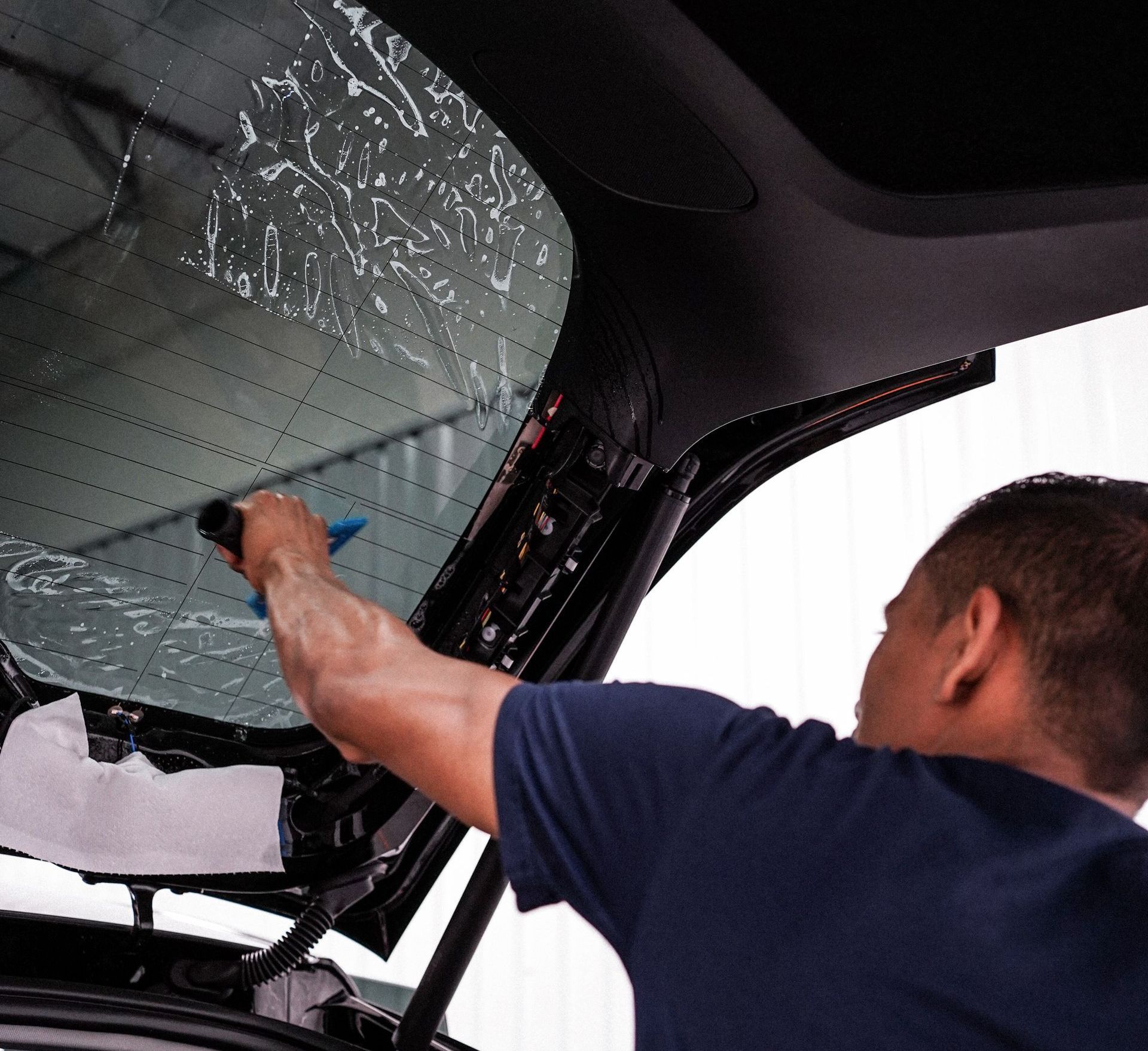 A box of xpel prime automotive window film next to a car