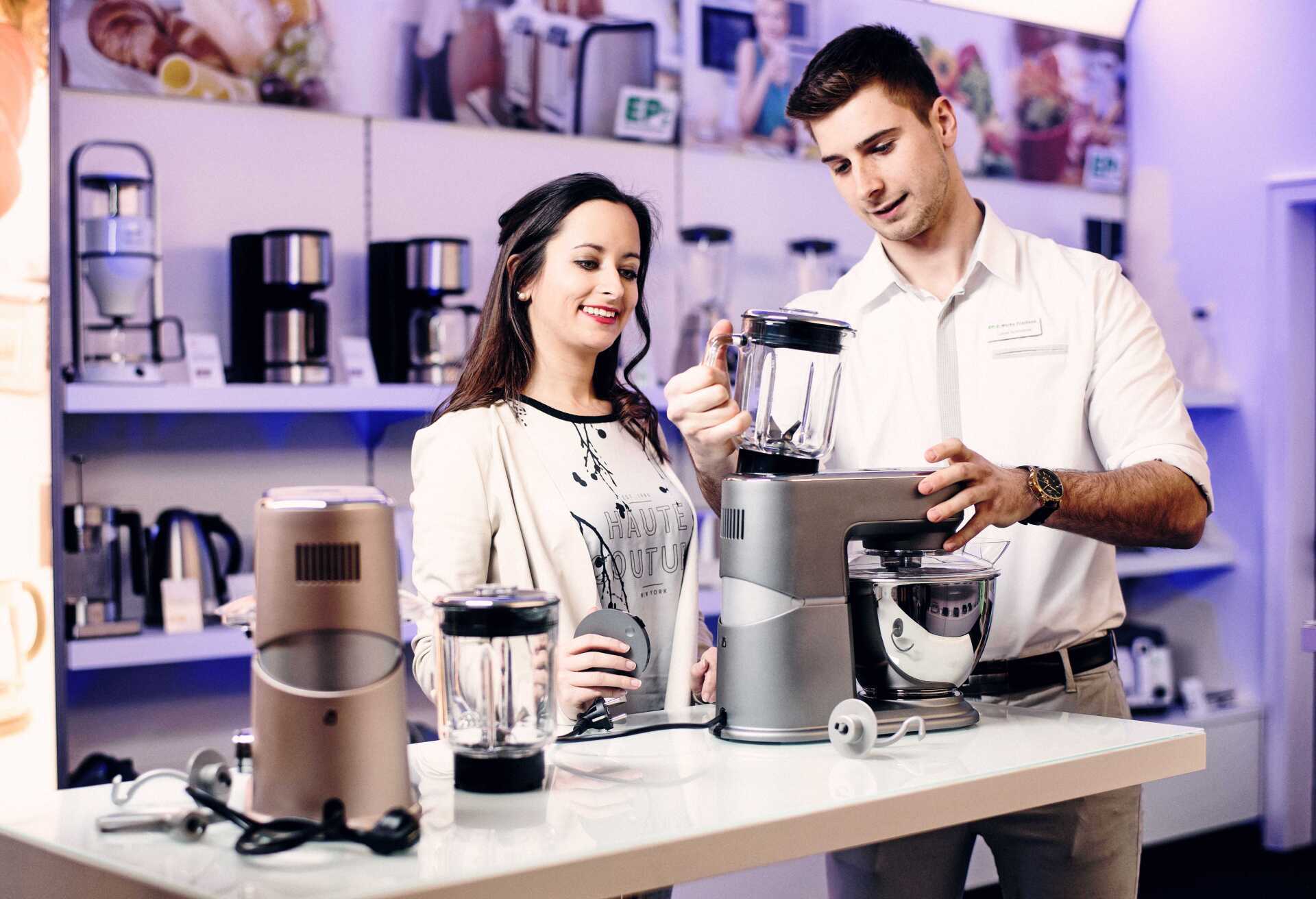 Mitarbeitende der E-Werke demonstrieren Kaffeemaschine im Verkaufsraum