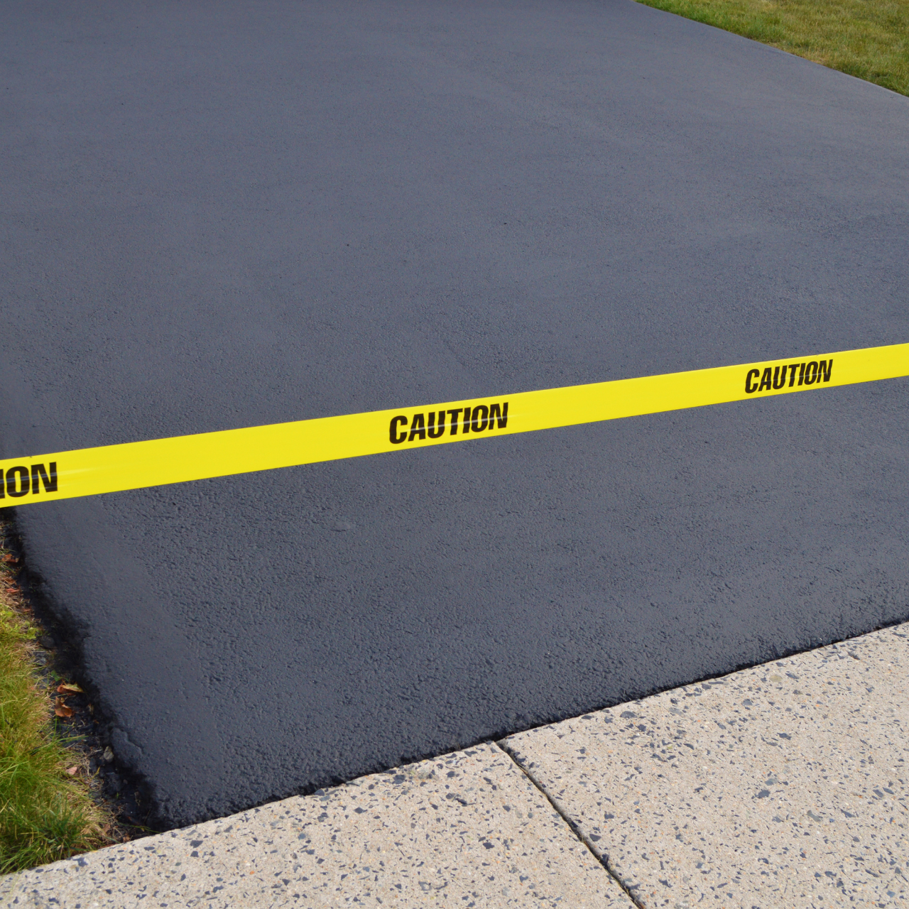 Freshly paved driveway with yellow