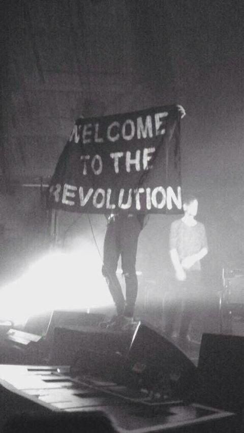 A man is holding a sign that says welcome to the revolution