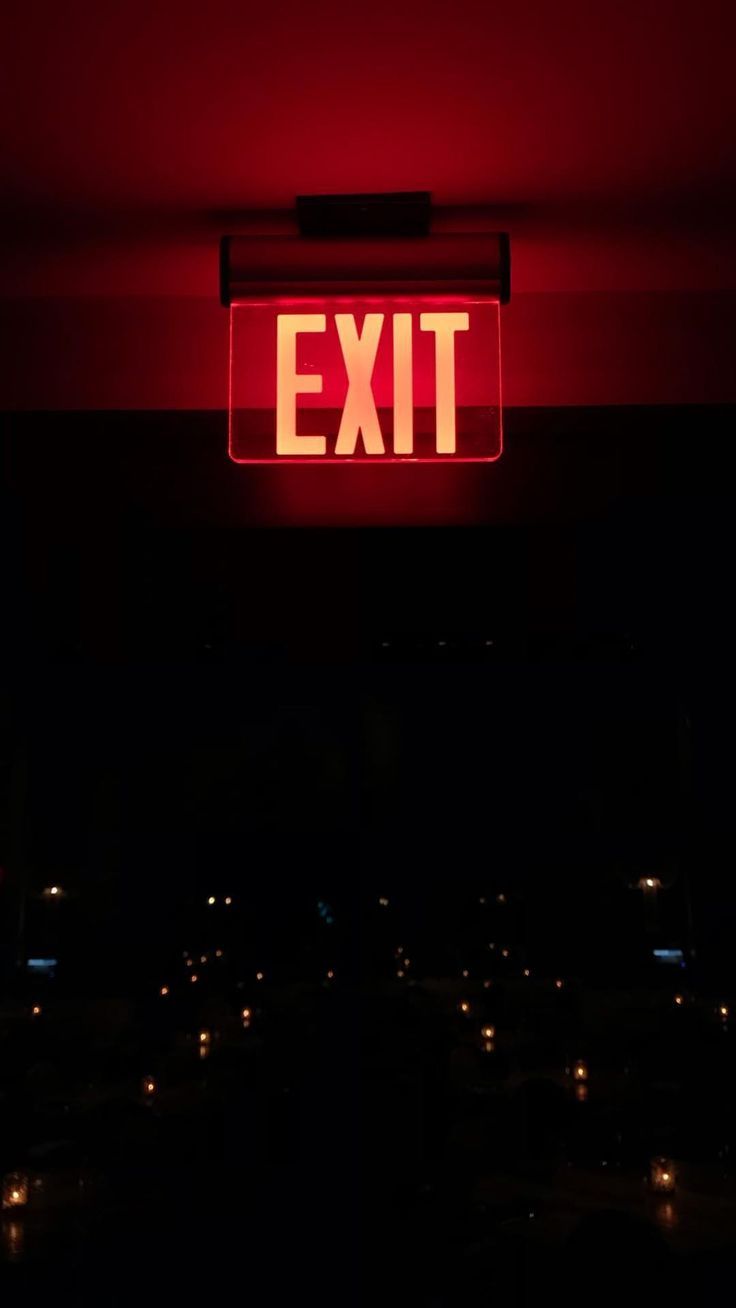 A red exit sign is lit up in the dark.