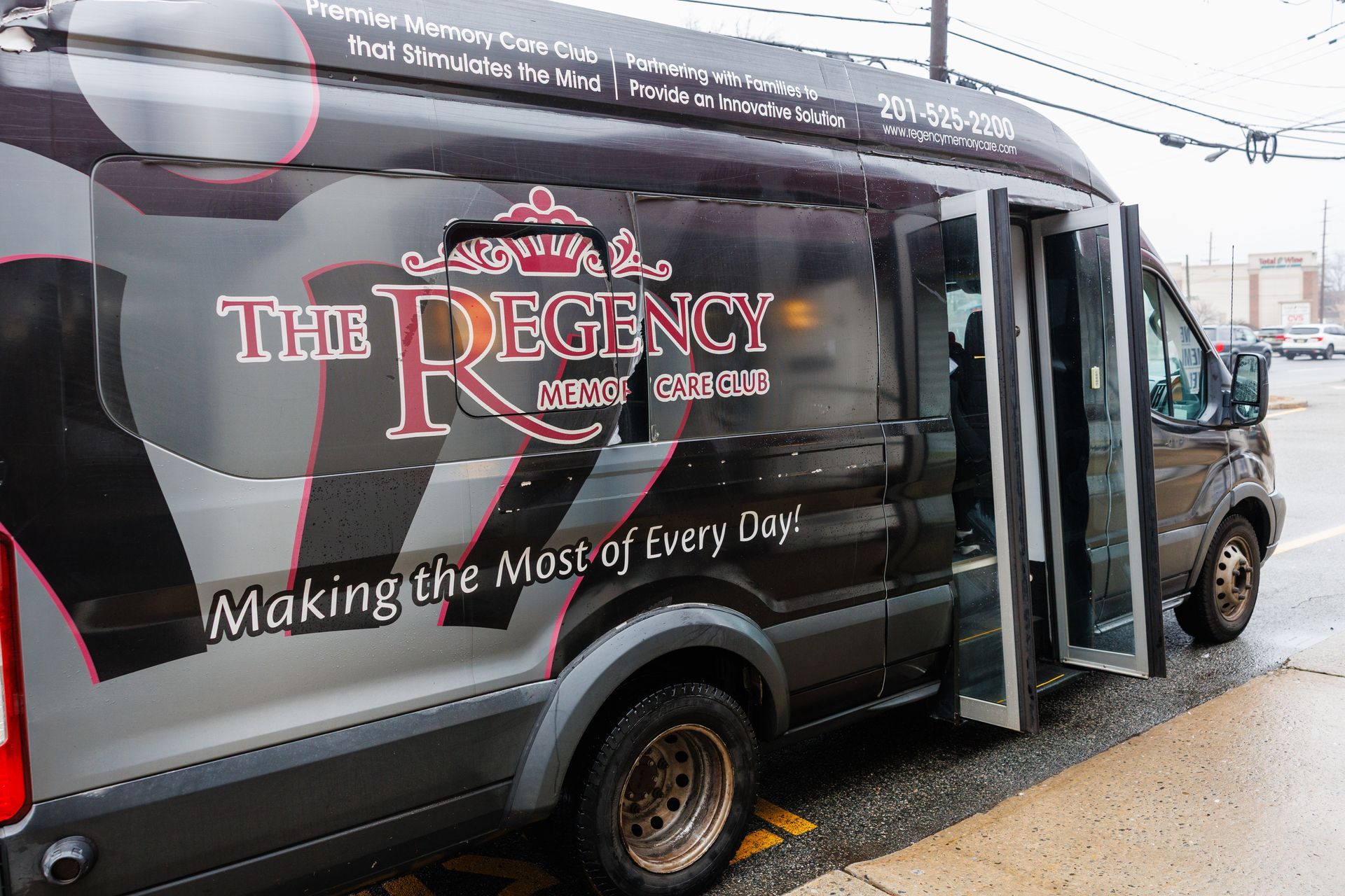 Black Regency shuttle van with side door open and slogan “Making the Most of Every Day”