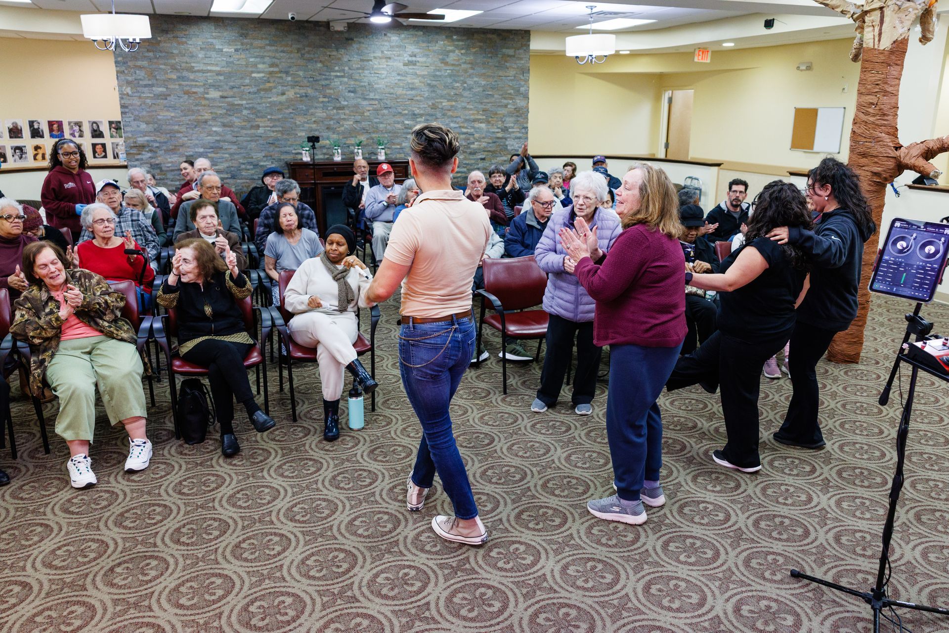 People gathered in a community hall watching two performers address the crowd.
