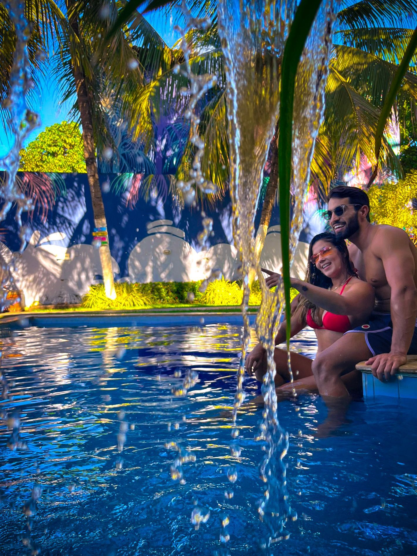 Piscina da Pousada Unaí em Porto de Galinhas, cercada por jardim e área de descanso.