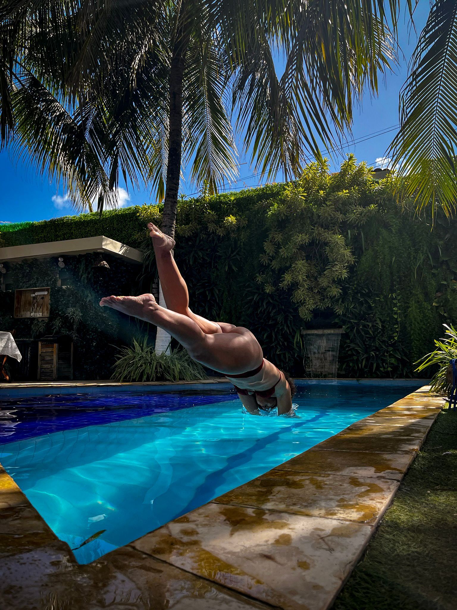 Piscina da Pousada Unaí em Porto de Galinhas, cercada por jardim e área de descanso.