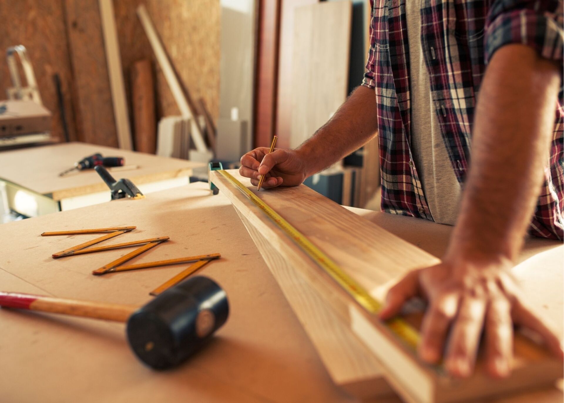 Picture of a construction worker measuring out lumber
