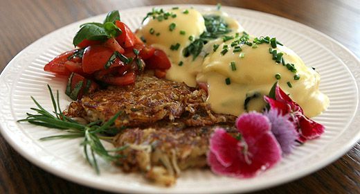 A white plate topped with food and flowers on a wooden table.