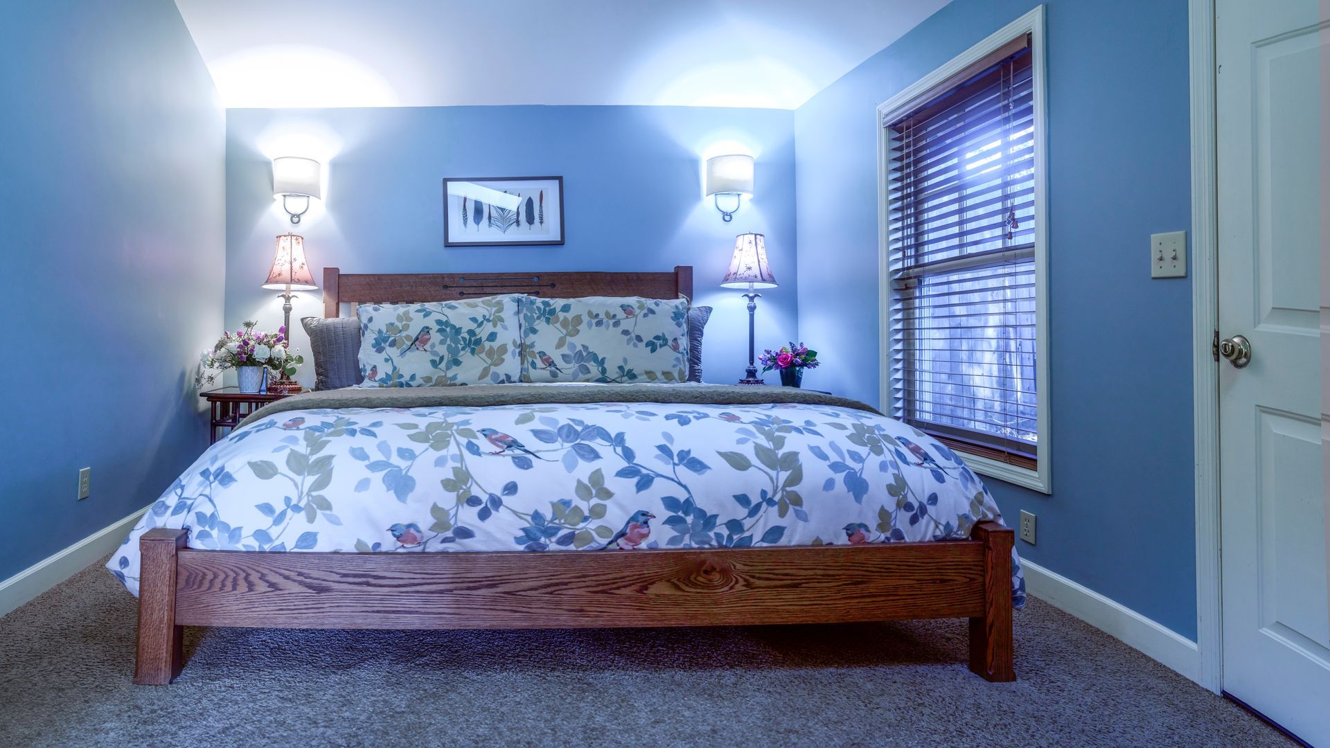 A bedroom with blue walls and a king size bed.