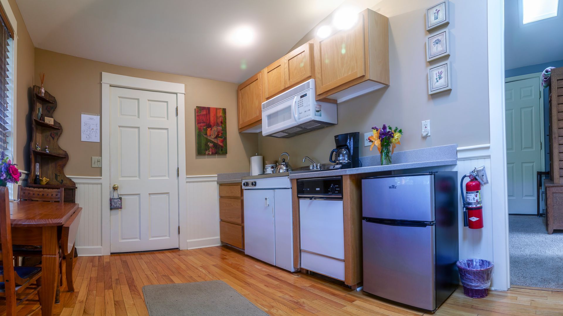 A kitchen with stainless steel appliances , wooden cabinets , a refrigerator and a microwave.