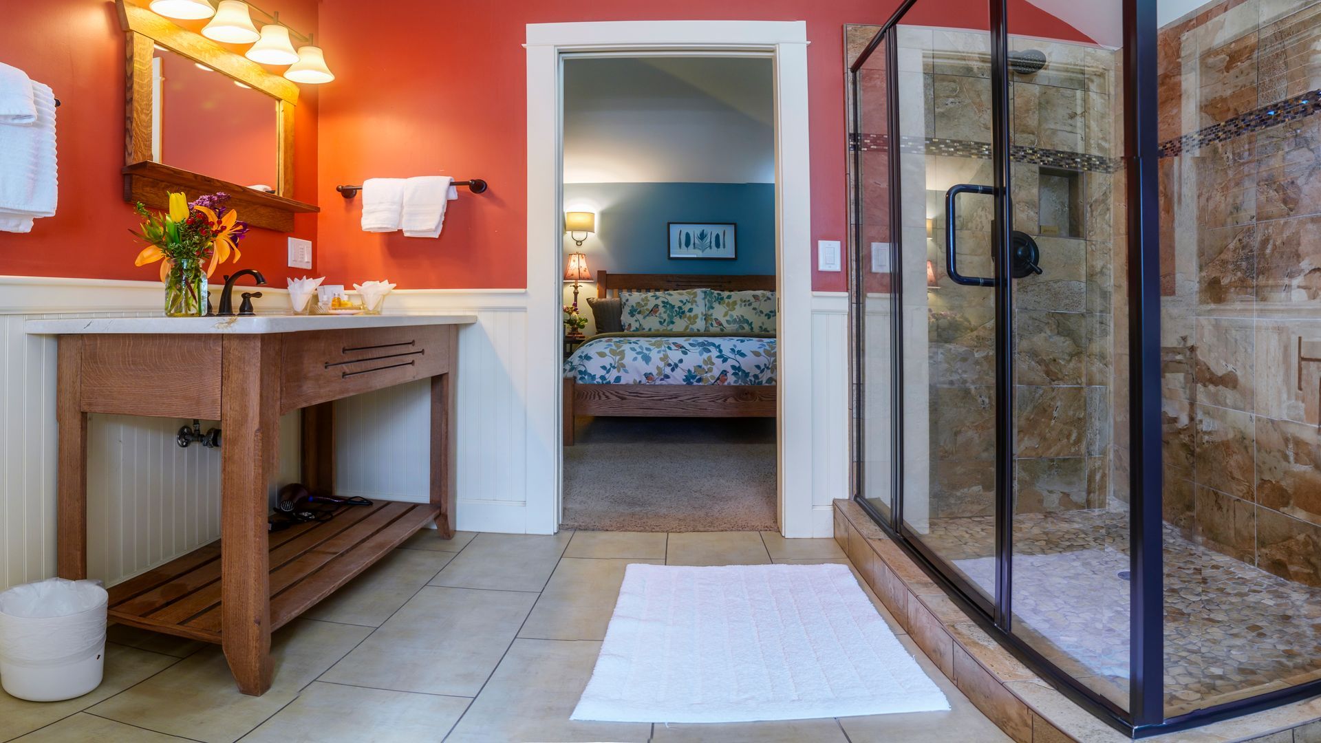 A bathroom with a walk in shower and a sink