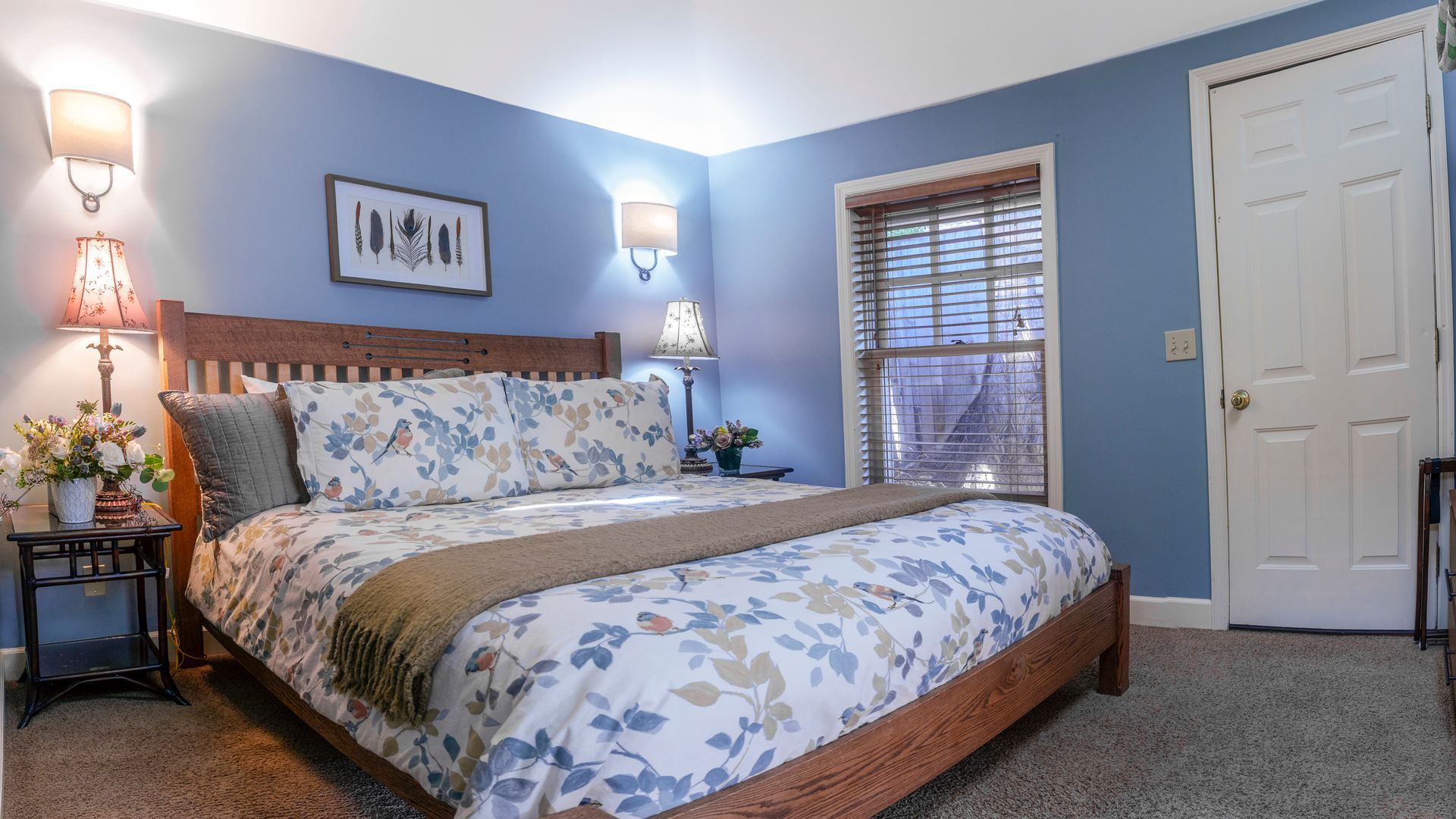 A bedroom with a king size bed and blue walls.