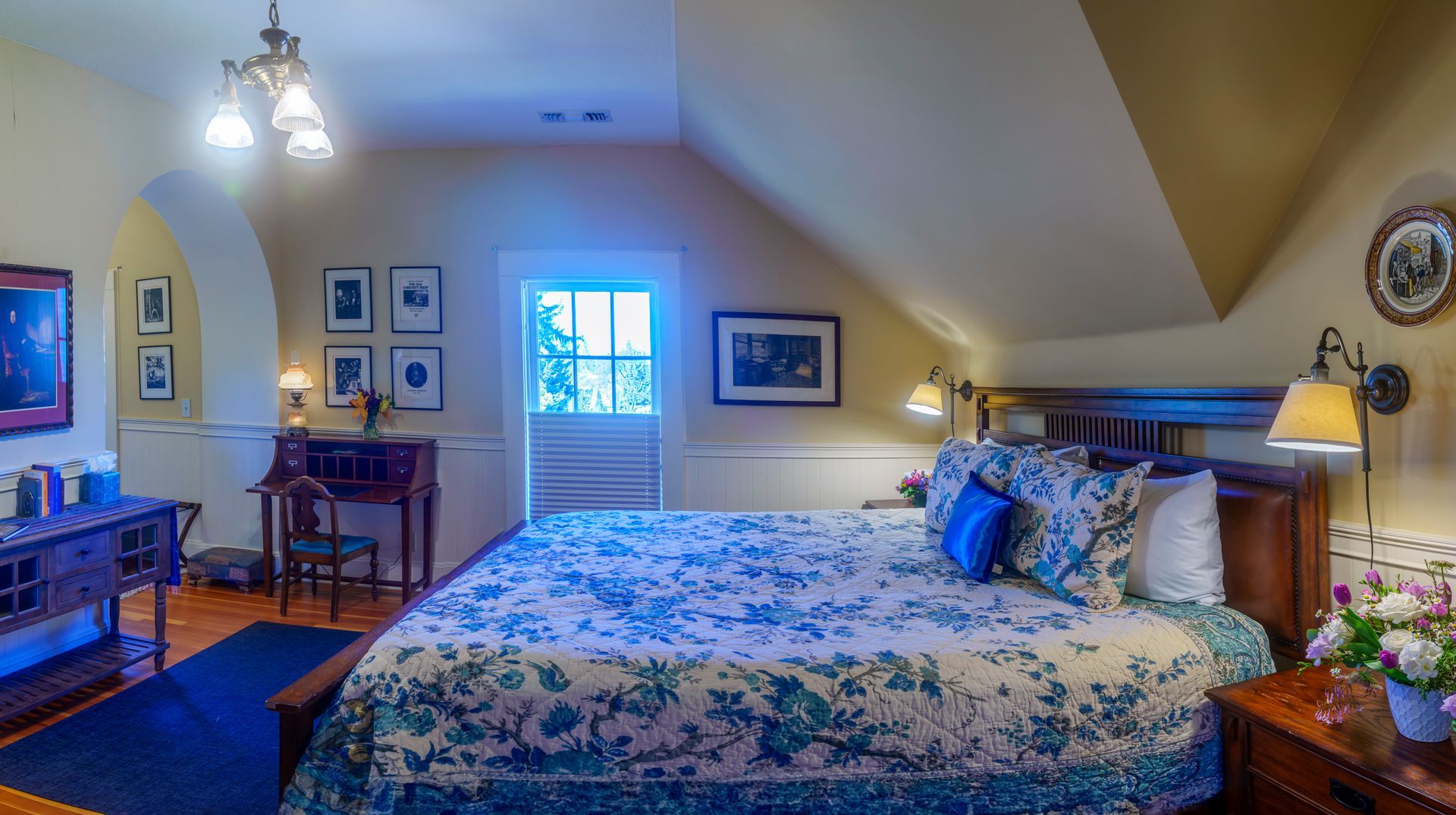 A bedroom with a king size bed and a desk.