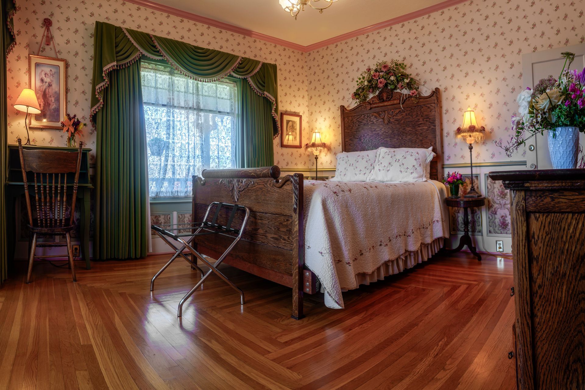 A bedroom with a bed , dresser , chair and window.