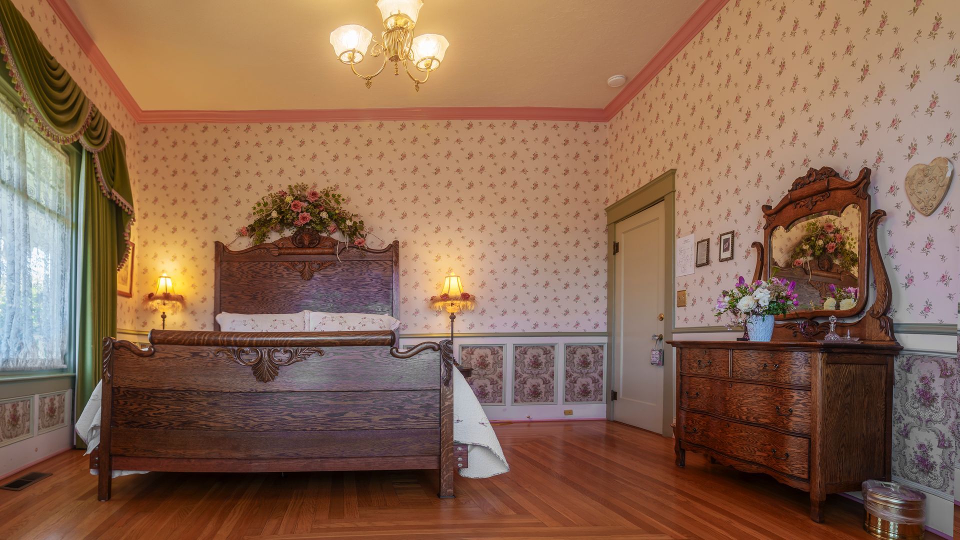 A bedroom with a bed , dresser and mirror.